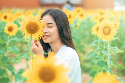 Close-up of woman holding yellow dandelion flower