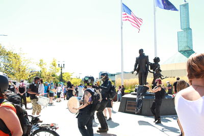 People on street against clear sky in city