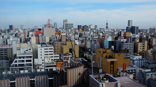 High angle view of city buildings against cloudy sky