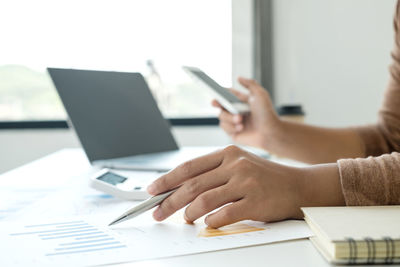 Midsection of man using laptop on table