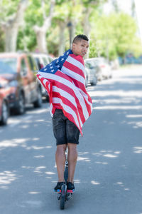 Low section of man walking on road in city