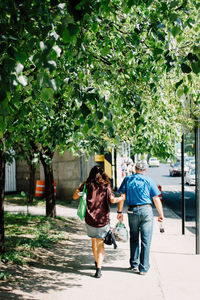 Full length rear view of man and woman walking outdoors