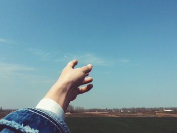 Cropped image of person pointing at sky