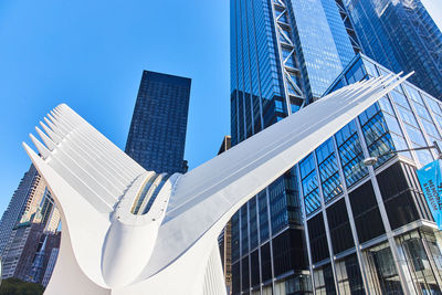 Low angle view of modern buildings against clear blue sky