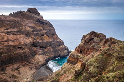 Rock formations by sea against sky