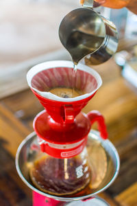 Cropped hand preparing coffee on table