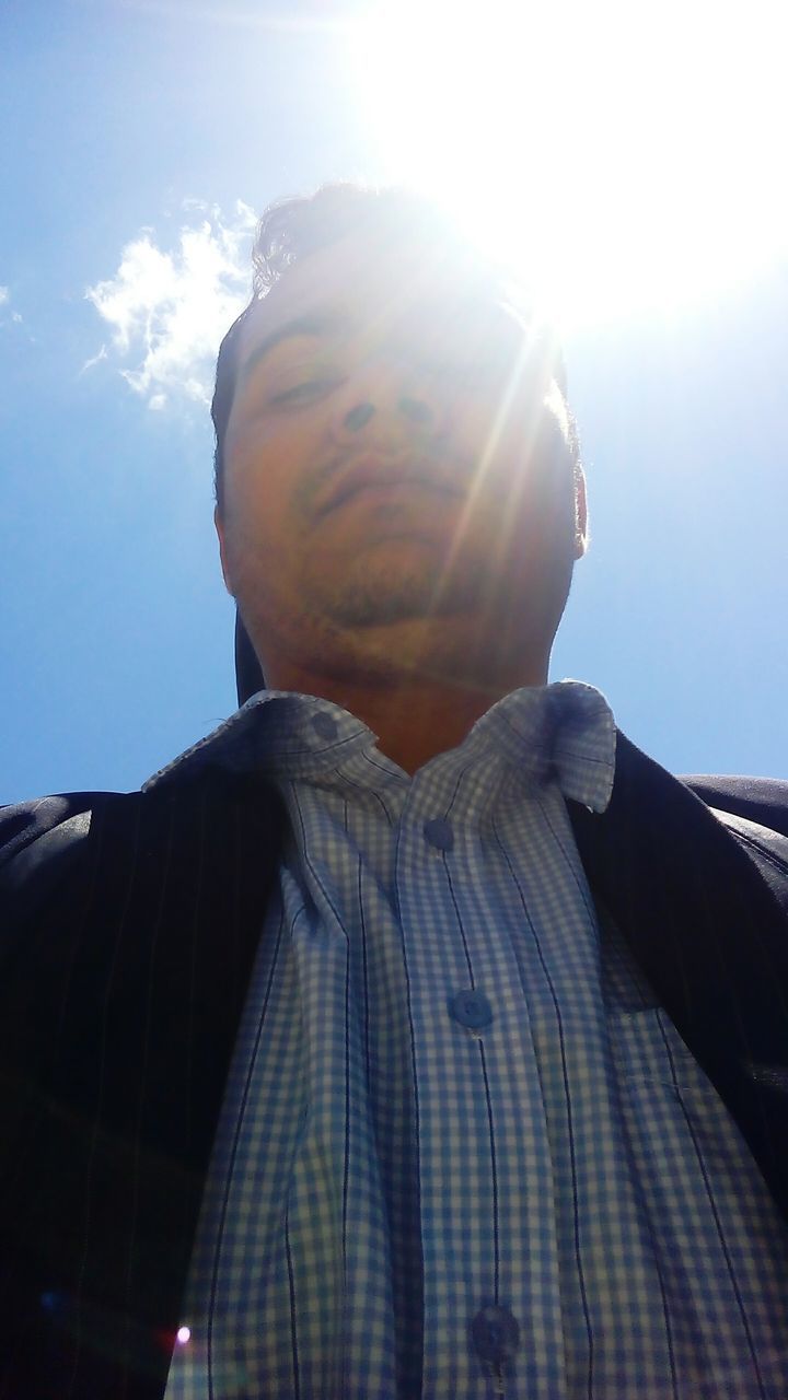 LOW ANGLE VIEW OF MAN AGAINST SKY ON SUNNY DAY
