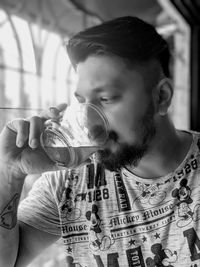 Portrait of young man drinking glass