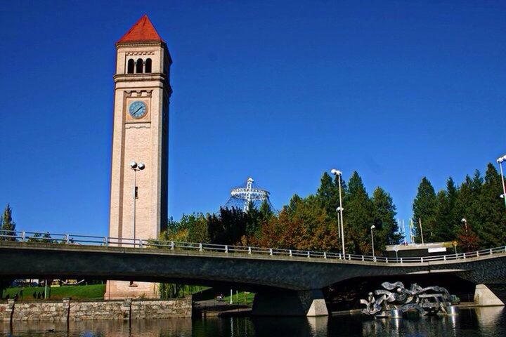 architecture, built structure, clear sky, building exterior, blue, low angle view, copy space, tower, tree, city, travel destinations, bridge - man made structure, railing, arch, day, outdoors, clock tower, famous place, connection, guidance