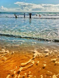 People on beach against sky