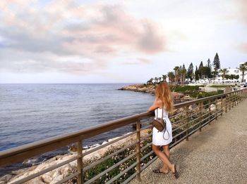 Woman looking at sea against sky