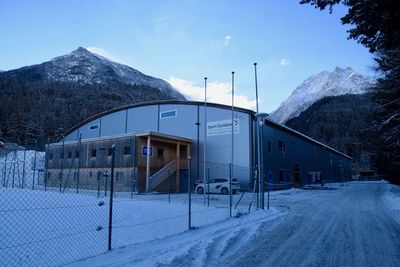 Built structure on snowcapped mountain against sky