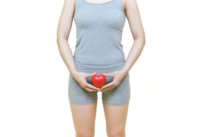 Midsection of woman standing against white background