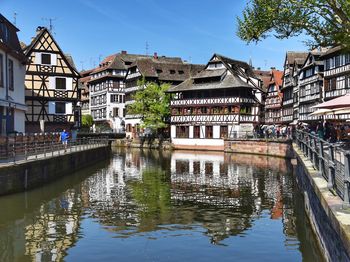 Canal amidst buildings in city against sky