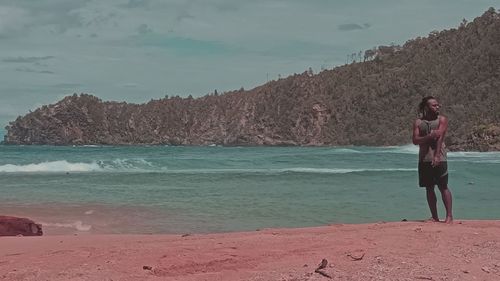 Full length of man standing on beach against sky