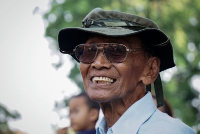 Close-up portrait of happy senior man wearing sunglasses outdoors