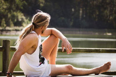 Midsection of woman sitting by lake