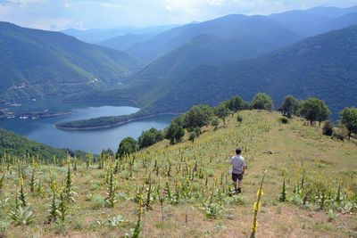 A man walking on a hill on chilingira trail on a hot summer day. vacha reservoir, bulgaria.