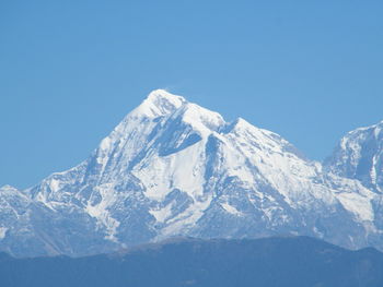 Scenic view of snowcapped mountains against clear blue sky