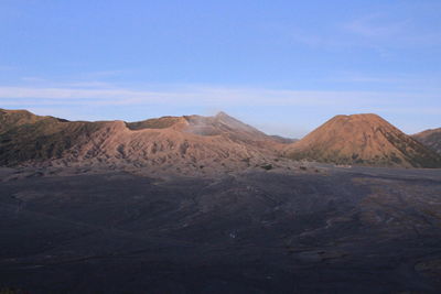 Scenic view of arid landscape and mountains against sky