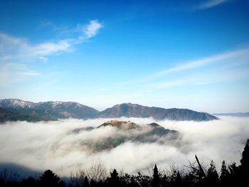 Scenic view of mountain range against cloudy sky