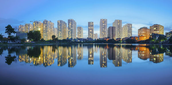 Reflection of buildings in lake against sky