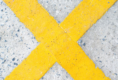 High angle view of yellow arrow symbol on street