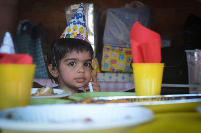 Close-up of boy wearing party hat at home