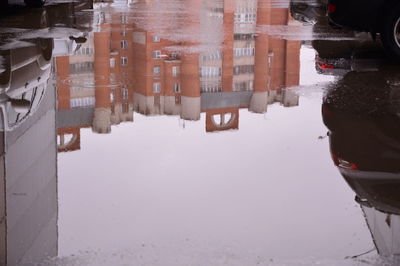 Reflection of buildings in city during winter