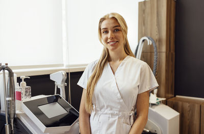 Portrait of young woman standing in hospital