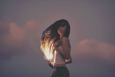 Portrait of woman standing against sky