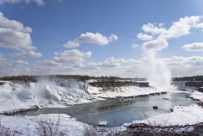 Scenic view of waterfall against sky