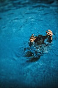 High angle view of woman drowning in swimming pool