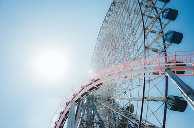 Low angle view of ferris wheel against blue sky