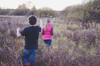 Rear view of children on field