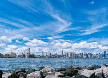 Scenic view of river in front of city against sky