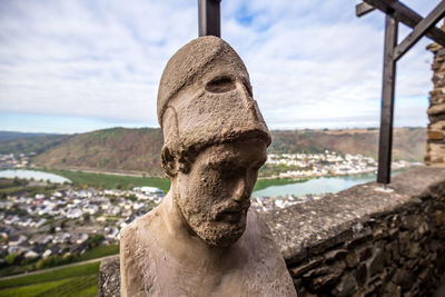 Close-up of old statue against sky