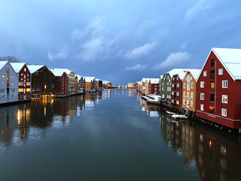 Canal amidst houses and buildings against sky