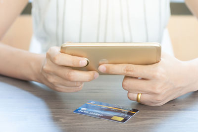 Close-up of man using mobile phone on table