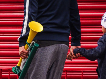 Midsection of man holding red umbrella