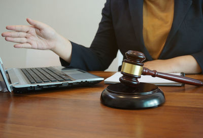 Midsection of man using laptop on table