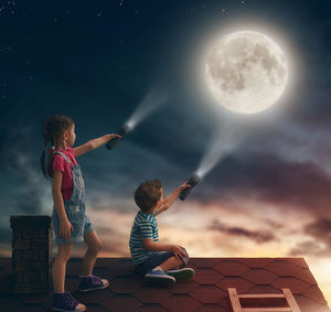 Digital composite image of people against moon