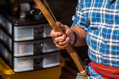 Midsection of man working on wood