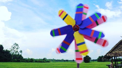 Multi colored toy on field against sky