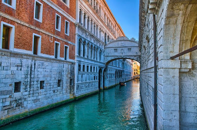 Bridge over canal amidst buildings in city