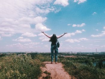 Woman standing on field against sky