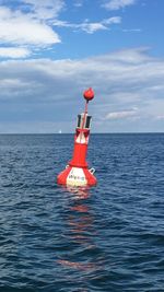 Lighthouse on sea against sky