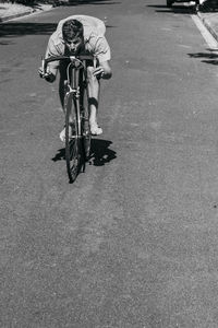 Side view of man riding bicycle on street