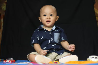 Portrait of cute baby girl sitting with toy