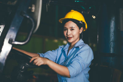 Portrait of young woman standing in factory